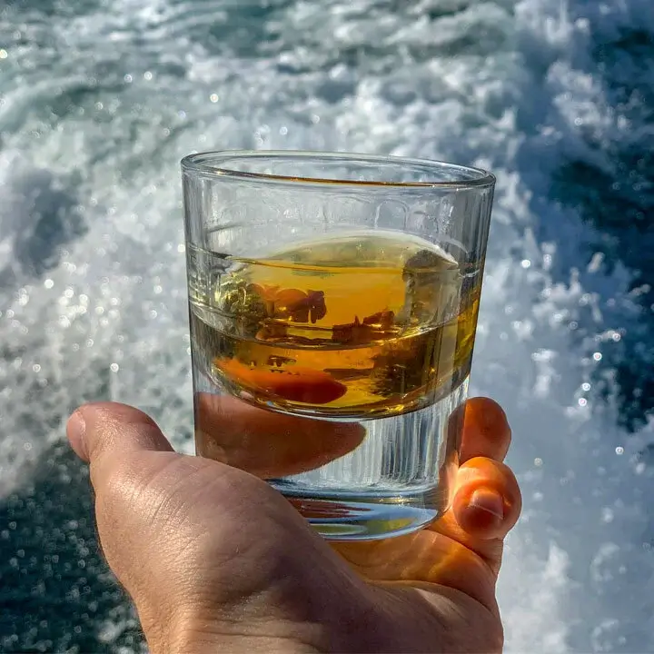 Holding alcohol in a glass cup near the sea