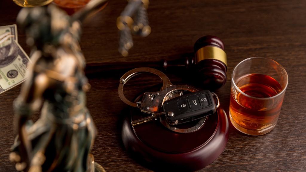 Car keys with handcuffs and an alcoholic drink