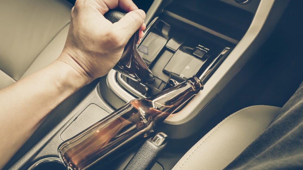driver holding alcoholic bottle while driving