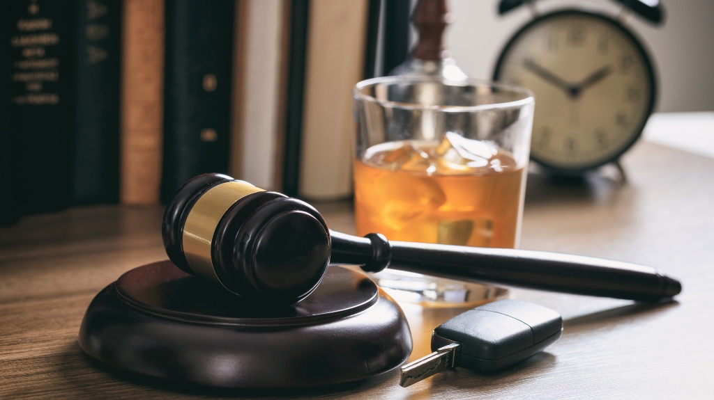 law gavel, alcohol and car keys on a wooden desk