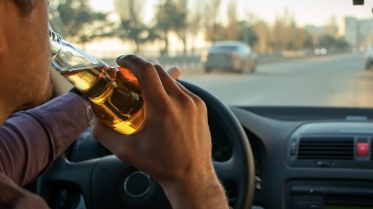 man drinking alcohol while driving