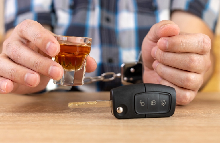 A glass of alcohol and car keys
