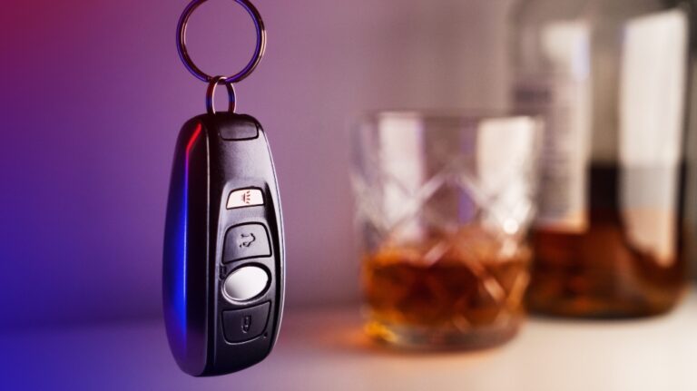 Car keys with glass and bottle of liquor
