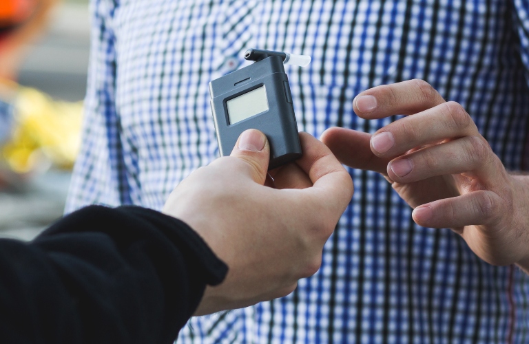 Policeman giving a breathalyzer to a driver