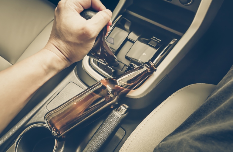 driver holding alcoholic bottle while driving