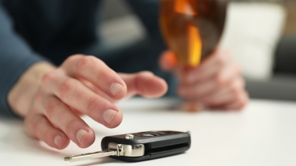 Drunk man reaching for car keys indoors