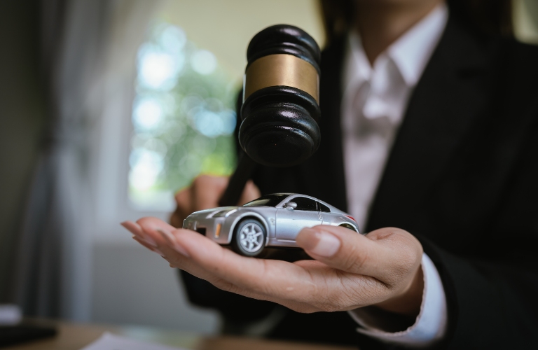Lawyer’s desk with gavel, contract, and toy car symbolizing justice